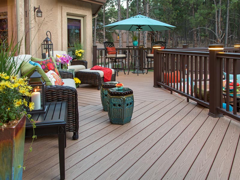 Beautiful backyard deck with built-in lighting and fully decorated with vibrant and colorful furniture and decor